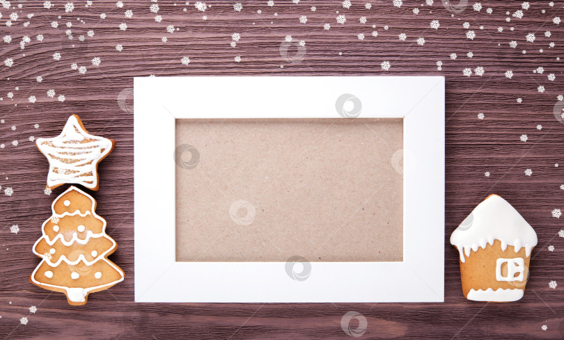 Скачать Пряничный домик и рождественская елка на деревянном фоне. Белая рамка. фотосток Ozero