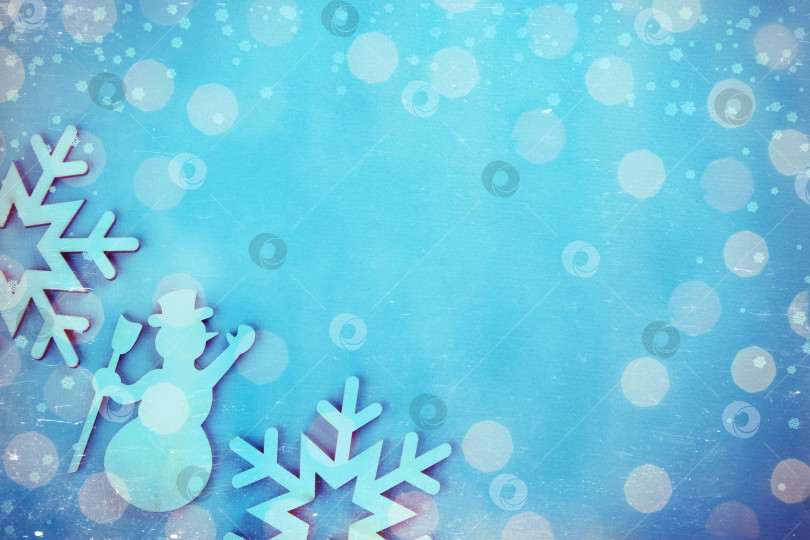 Скачать Деревянный игрушечный снеговик на праздничном фоне с яркими рождественскими и новогодними огоньками от гирлянды. Винтажная тонировка и царапины. фотосток Ozero