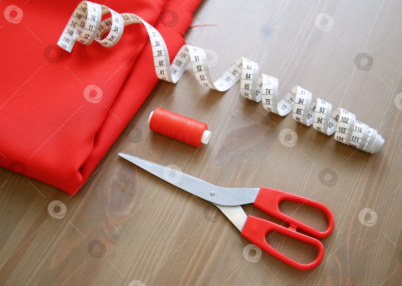 Скачать Ткань, ножницы, нитки, измерительная лента. Принадлежности для шитья. фотосток Ozero