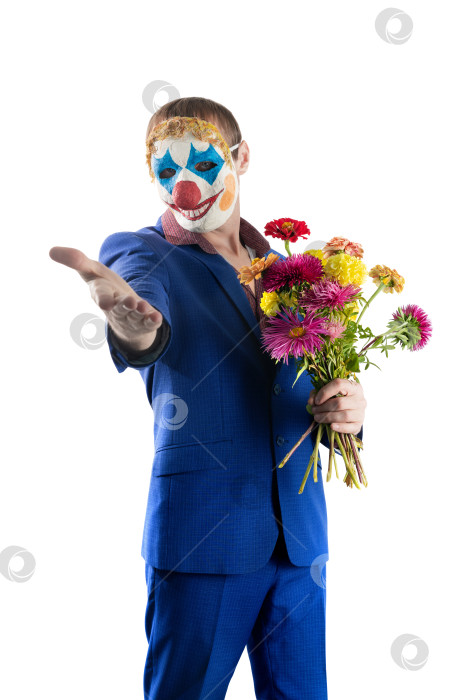Скачать Мужчина в маске клоуна с цветами в руках. Приглашающий жест. фотосток Ozero