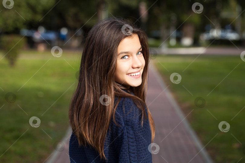 Скачать Симпатичная маленькая девочка-брюнетка позирует на фоне осеннего парка фотосток Ozero