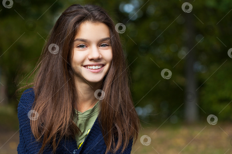 Скачать Симпатичная маленькая девочка-брюнетка позирует на фоне осеннего парка фотосток Ozero