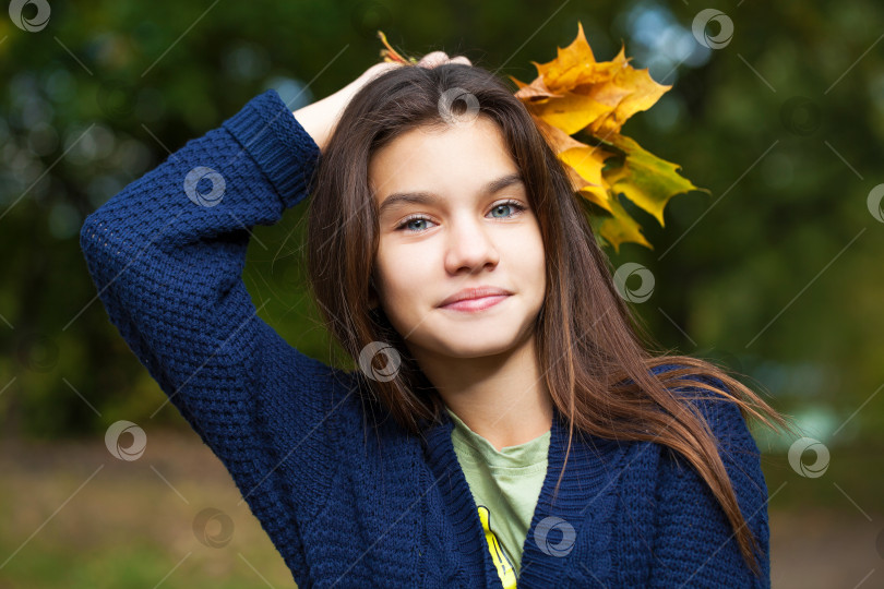 Скачать Симпатичная маленькая девочка-брюнетка позирует на фоне осеннего парка фотосток Ozero