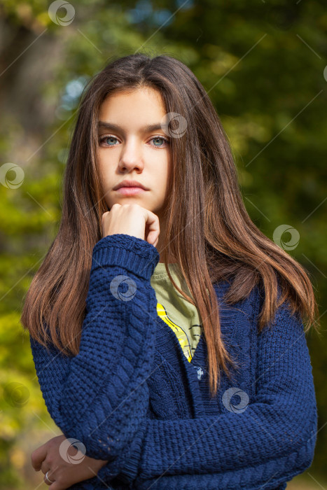 Скачать Симпатичная маленькая девочка-брюнетка позирует на фоне осеннего парка фотосток Ozero