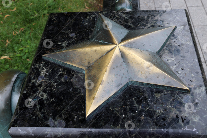 Скачать Москва, Россия - август 20, 2023: Медная звезда на мраморном основании в парке. Пятиконечная звезда – символ советской эпохи. фотосток Ozero