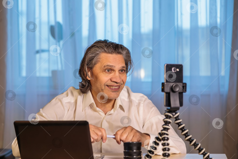 Скачать 50-летний блогер записывает видео для блога на свой смартфон. фотосток Ozero