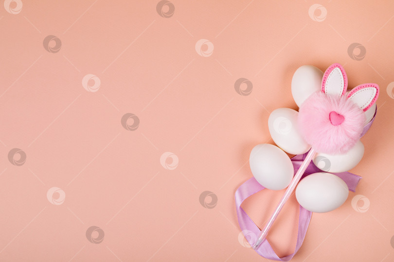 Скачать Пасха. Белые яйца с искусственным кроликом на однородном фоне. фотосток Ozero