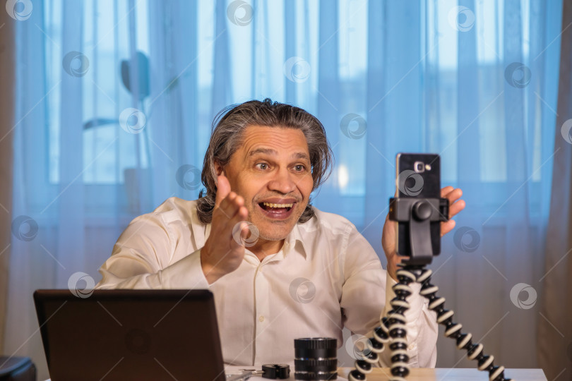 Скачать 50-летний блогер записывает видео для блога на свой смартфон. фотосток Ozero