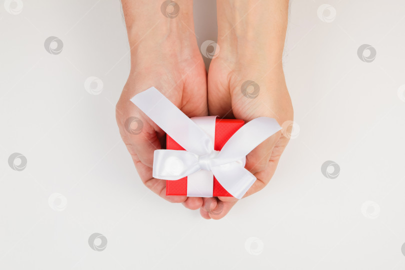Скачать Подарочная коробка в руках мужчины к празднику. Вид сверху. фотосток Ozero