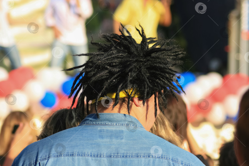 Скачать Мужчина в черном парике с дредами на уличном концерте. фотосток Ozero