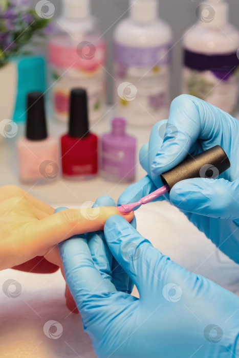 Скачать В салоне красоты женщине делают маникюр, покрывают ноготь лаком. фотосток Ozero
