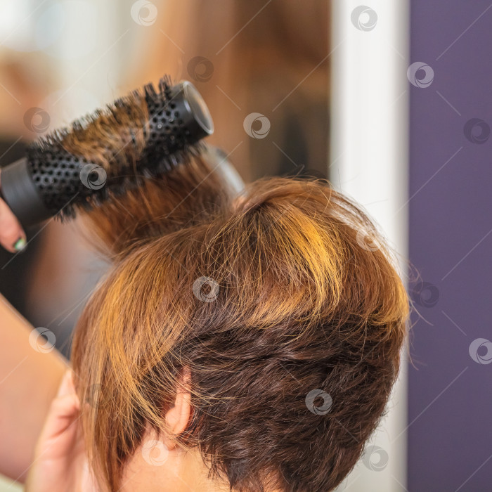 Скачать Женщина расчесывает волосы расческой в салоне красоты фотосток Ozero