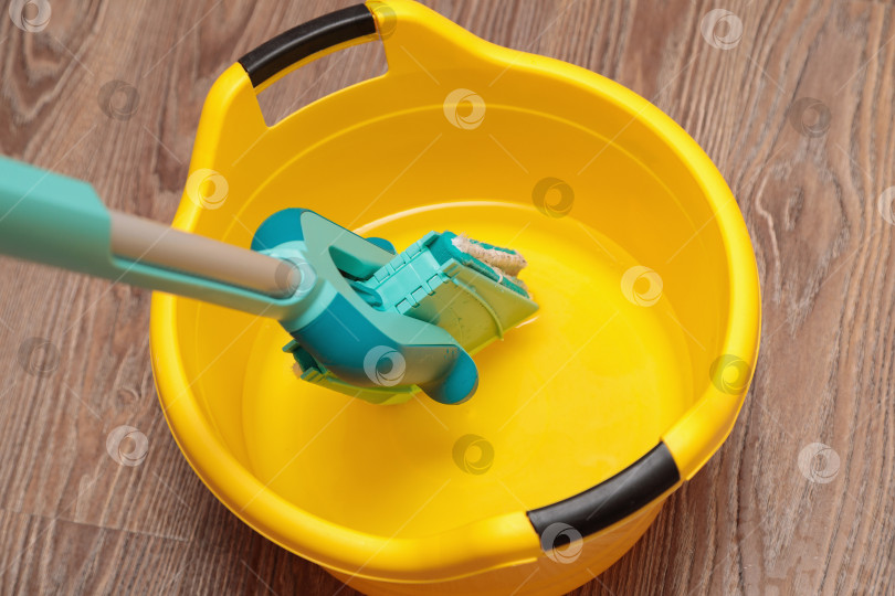 Скачать Синяя швабра с желтым тазиком для мытья посуды. фотосток Ozero