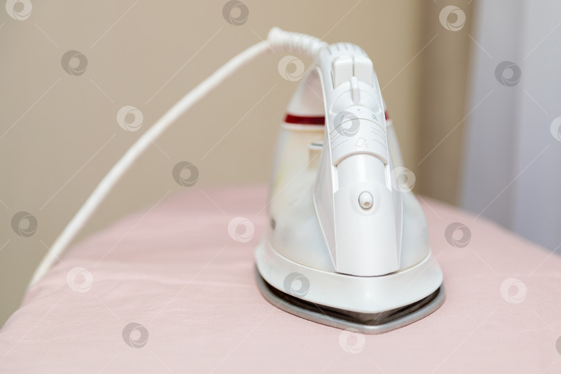 Скачать Утюг на гладильной доске с розовым постельным бельем фотосток Ozero