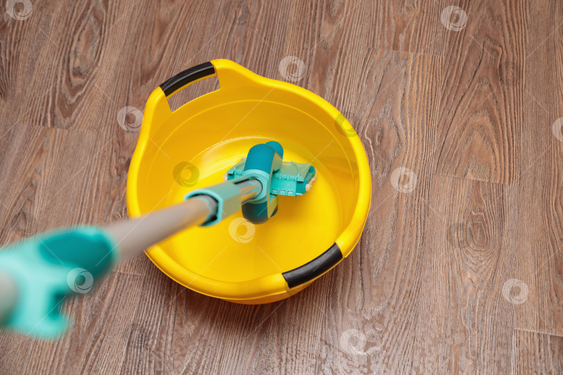 Скачать Синяя швабра с желтым тазиком для мытья посуды. фотосток Ozero