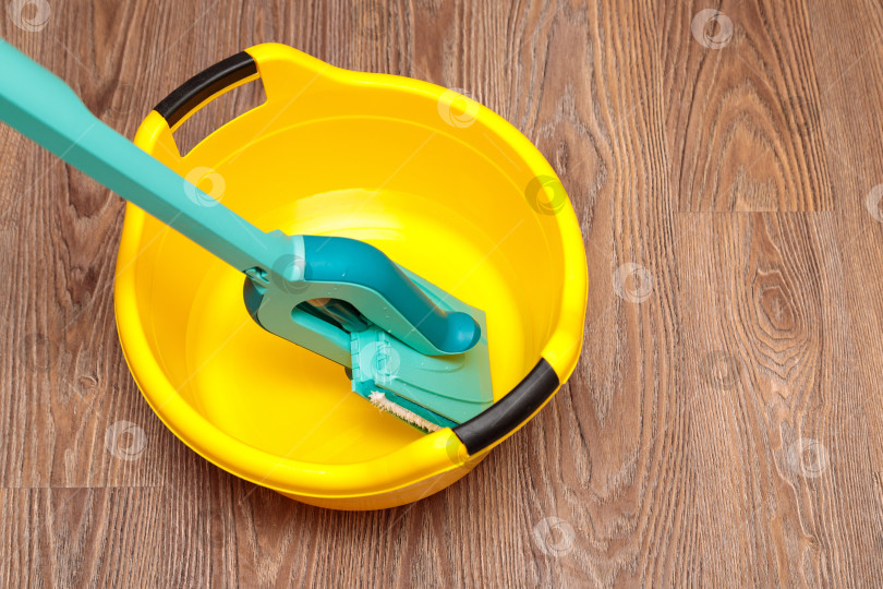 Скачать Синяя швабра с желтым тазиком для мытья посуды. фотосток Ozero