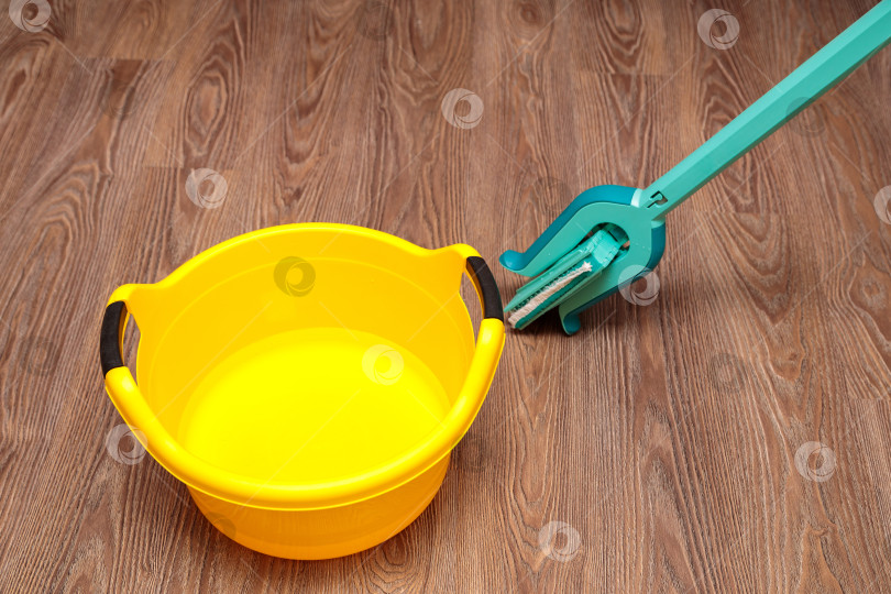 Скачать Синяя швабра с желтым тазиком для мытья посуды. фотосток Ozero