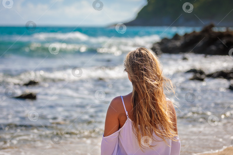 Скачать Молодая красивая девушка на берегу моря с развивающимися волосами фотосток Ozero