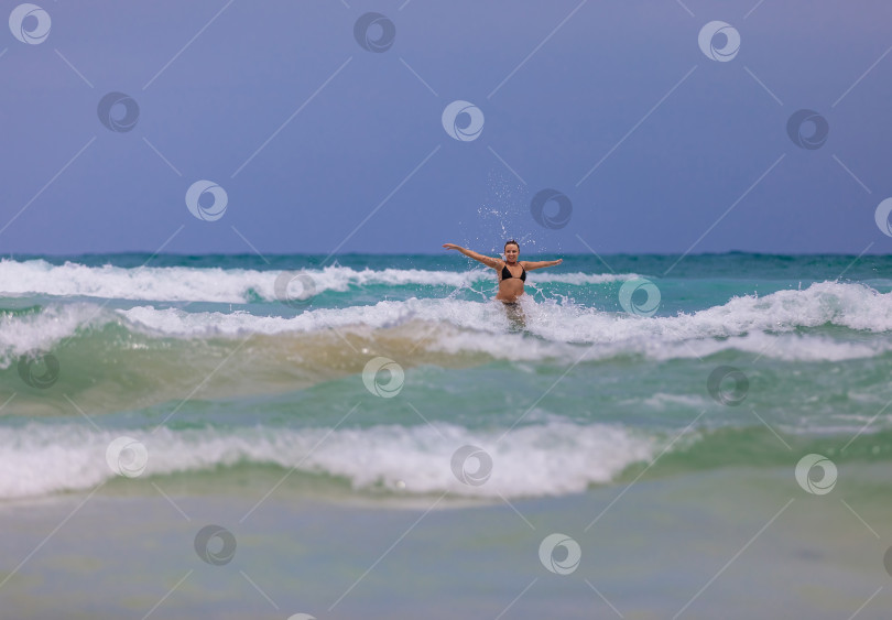 Скачать Молодая красивая девушка от счастья прыгает в море, радуется волнам фотосток Ozero