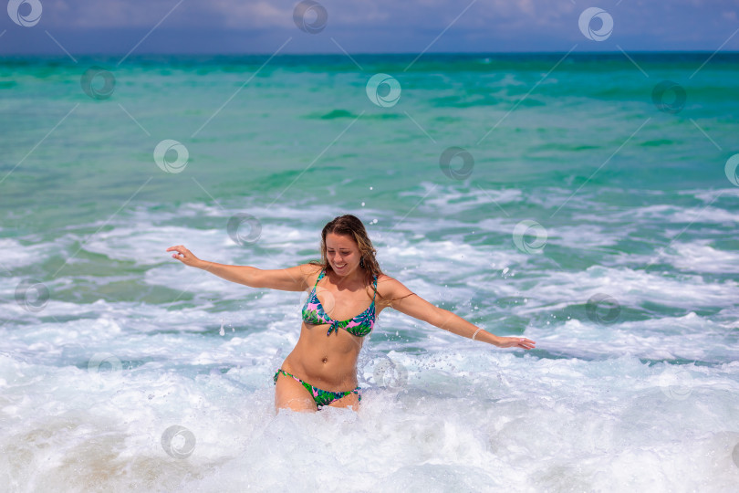 Скачать Молодая красивая девушка от счастья прыгает в море, радуется волнам фотосток Ozero