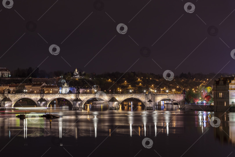 Скачать Карлов мост в вечерней Праге с разноцветными огнями от фонарей фотосток Ozero