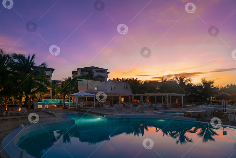 Скачать Красивый отель с бассейном на рассвете в золотых лучах солнца фотосток Ozero