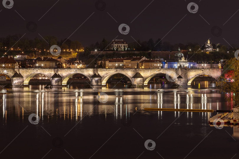 Скачать Карлов мост в вечерней Праге с разноцветными огнями от фонарей фотосток Ozero