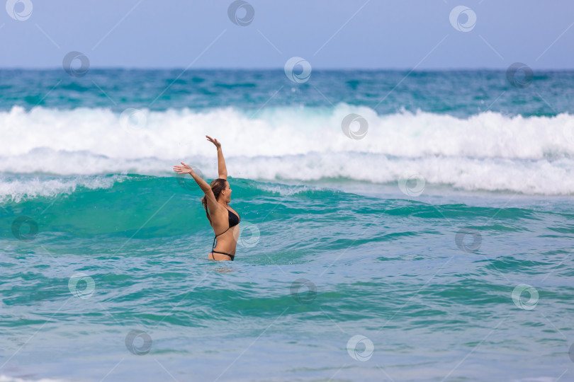 Скачать Молодая девушка в море радуется бурным волнам. фотосток Ozero