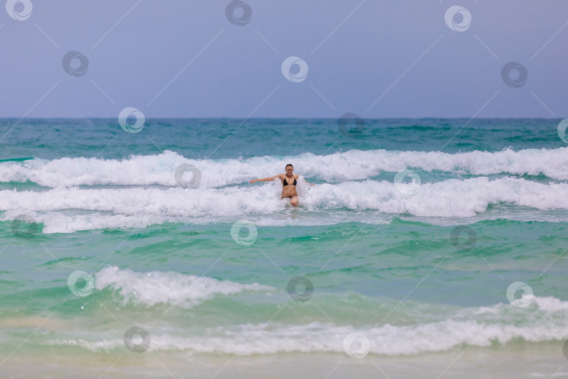 Скачать Молодая красивая девушка от счастья прыгает в море, радуется волнам фотосток Ozero