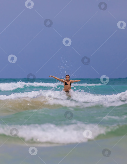 Скачать Молодая красивая девушка от счастья прыгает в море, радуется волнам фотосток Ozero
