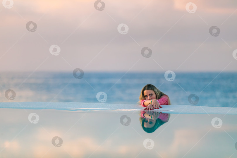 Скачать Молодая девушка на рассвете у морского бассейна, спокойная и расслабленная фотосток Ozero