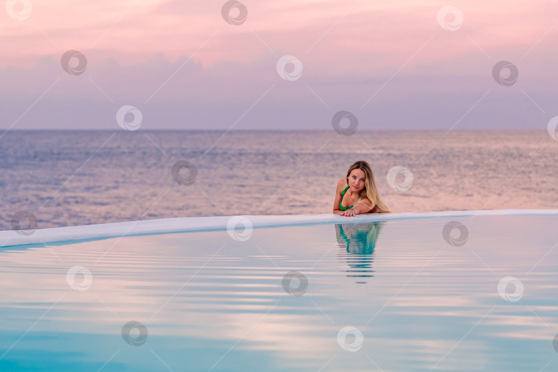 Скачать Молодая девушка на рассвете у морского бассейна, спокойная и расслабленная фотосток Ozero