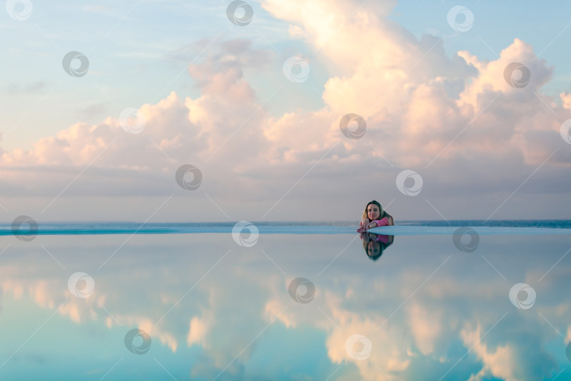 Скачать Молодая девушка на рассвете у морского бассейна, спокойная и расслабленная фотосток Ozero
