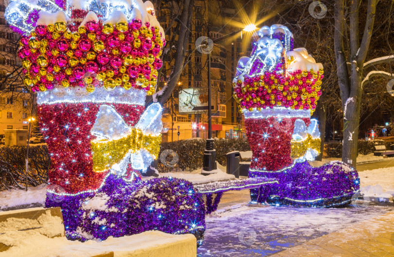 Скачать Новогодняя иллюминация города в сумерках. Необычные сапоги. фотосток Ozero