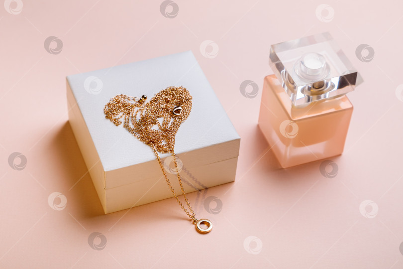 Скачать день святого Валентина. Духи и коробочка с цепочкой на розовом фоне. фотосток Ozero