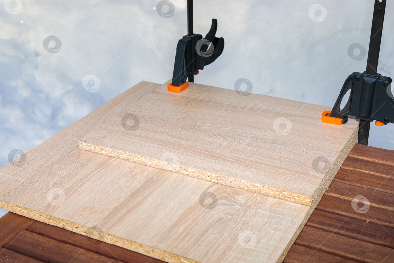 Скачать Плиты из ДСП склеиваются и скрепляются между собой двумя зажимами. фотосток Ozero