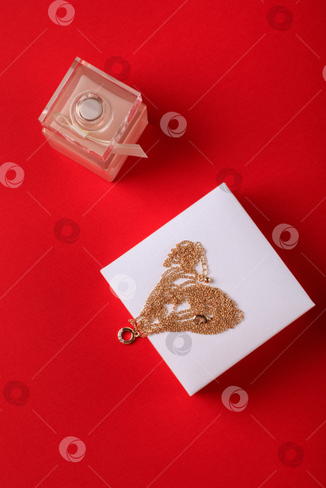 Скачать день святого Валентина. Духи и коробочка с цепочкой на красном фоне.. фотосток Ozero