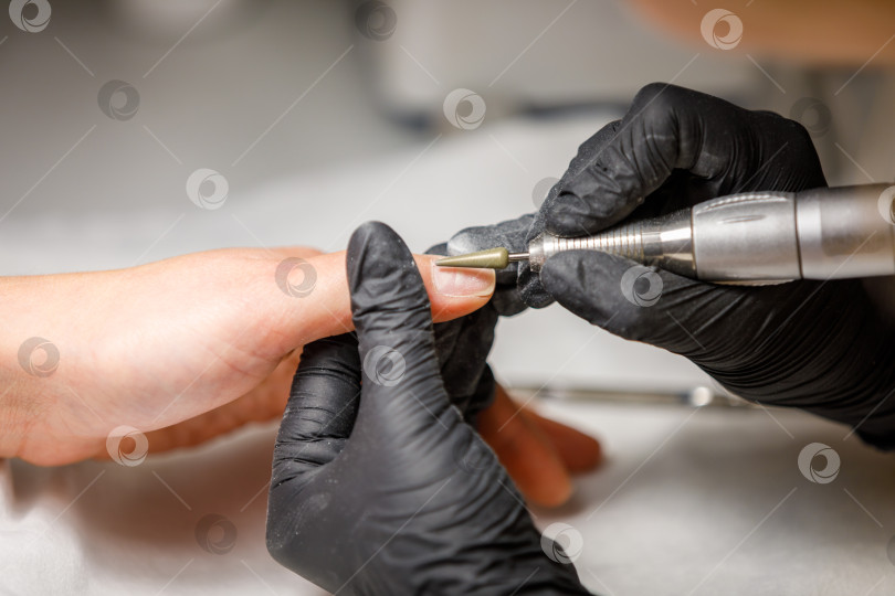 Скачать В студии красоты мастер делает аппаратный маникюр. Снятие гель-лака фрезой фотосток Ozero
