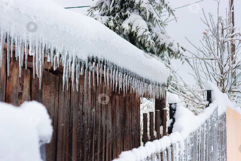 Скачать Зимой с крыши старого сарая свисают длинные сосульки фотосток Ozero