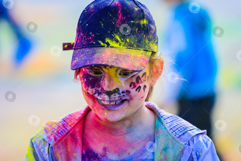 Скачать Россия, Москва - 25 июня 2017 года. Девушка с яркими красками на лице. Холи - традиционный праздник в Индии фотосток Ozero