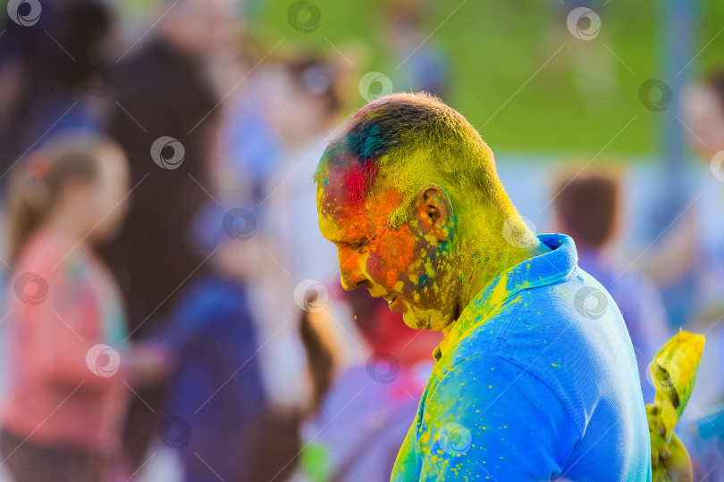 Скачать Россия, Москва - 25 июня 2017 года. Мужчина с яркими красками на лице. Холи - традиционный праздник в Индии фотосток Ozero