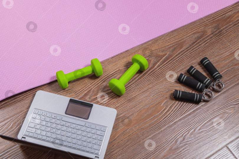 Скачать Коврик для фитнеса, гантели, эспандер и ноутбук для онлайн-тренировок дома. фотосток Ozero