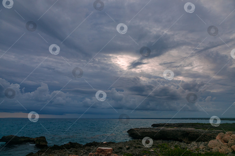 Скачать Спокойный закат на фоне темно-синего моря. На горизонте густые облака фотосток Ozero
