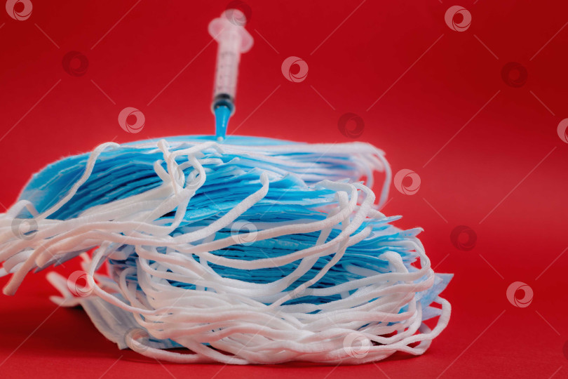 Скачать На столе лежит медицинская маска со шприцем и лекарством от коронавируса. фотосток Ozero