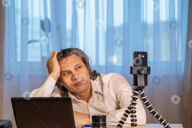 Скачать 50-летний блогер записывает видео для блога на свой смартфон. фотосток Ozero