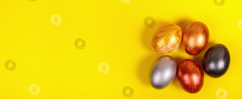 Скачать Разноцветные яйца на однородном желтом фоне с местом для текста. фотосток Ozero