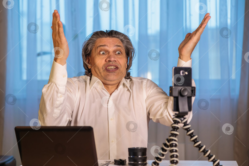 Скачать 50-летний блогер записывает видео для блога на свой смартфон. фотосток Ozero