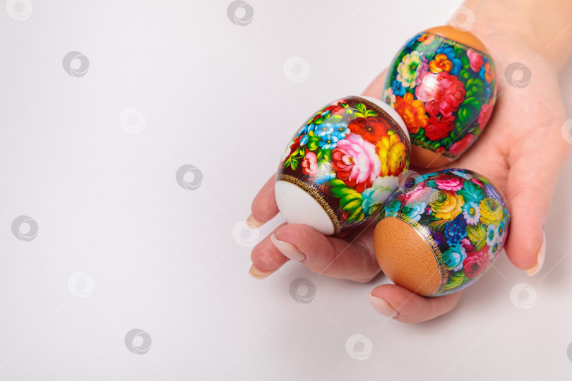 Скачать Пасха. Хохломские яйца в руках девушки, на светлом фоне. фотосток Ozero