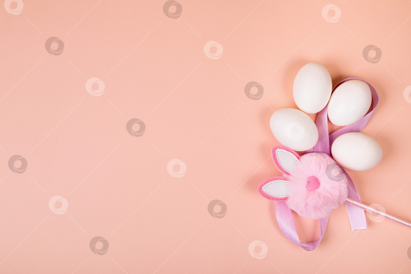 Скачать Пасха. Белые яйца с искусственным кроликом на однородном фоне. фотосток Ozero