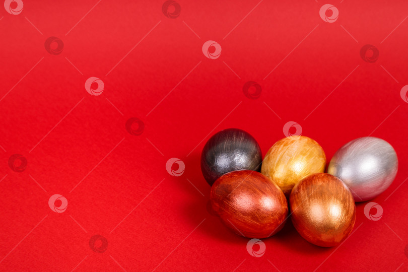 Скачать Разноцветные яйца на однородном красном фоне с местом для текста. фотосток Ozero